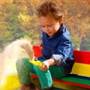 Sandkasten Ella mit Deckel / Sitzbänken Regenbogenfarben